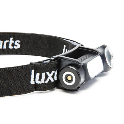 Multifunktionslampe 500 lm sort pandelampe med bred elastikrem med "lux" i hvid, rundt lys og cylindrisk batterirum.