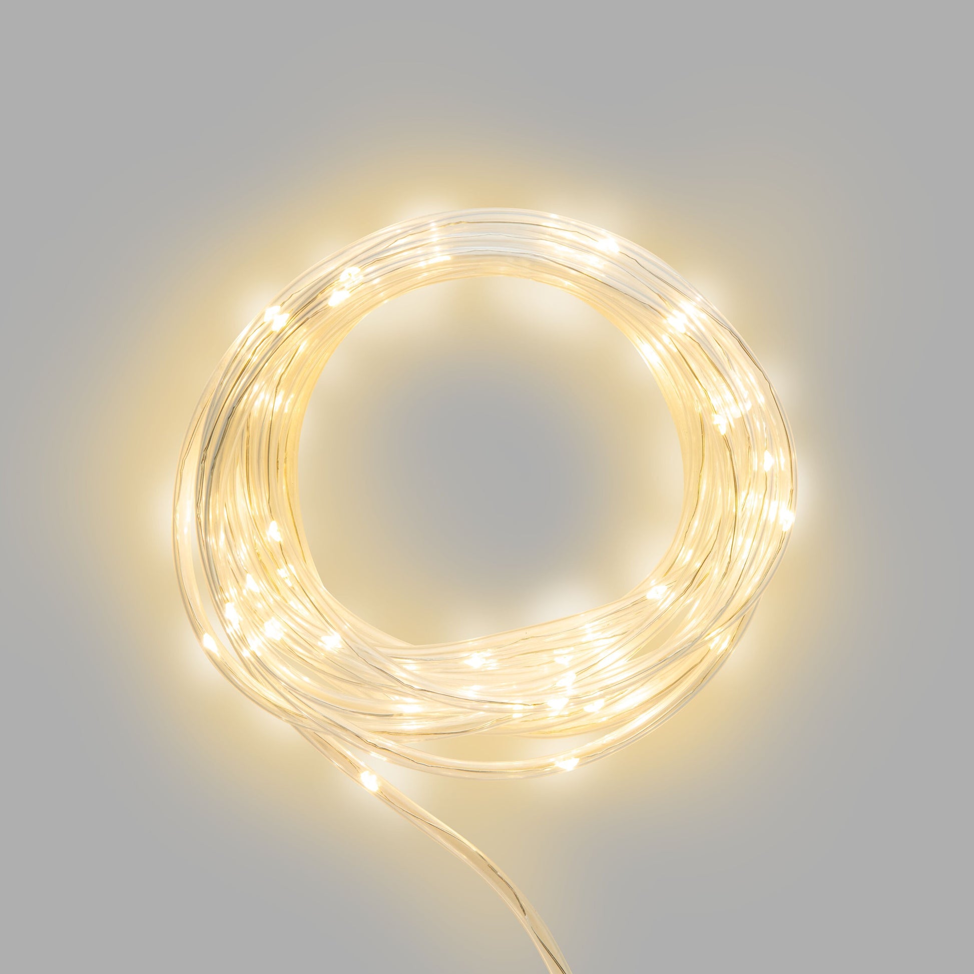 Rubicson solcelledrevet lyskæde 75 LED 7,5 m varm hvid glød snoet i cirkel mod ensfarvet grå baggrund.