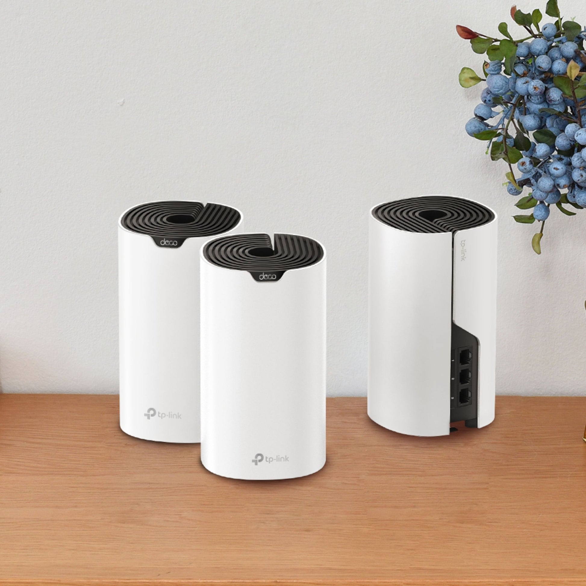 TP-Link Deco S7 Mesh AC1900 routere, hvide med sorte toppe, tre stk. på træbord.