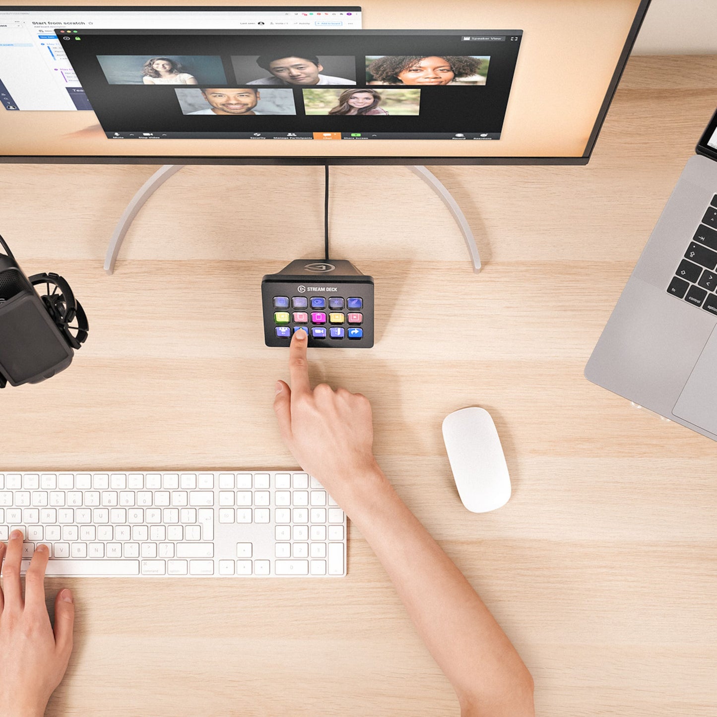 Elgato Stream Deck Mk. 2 med programmerbare knapper på skrivebord ved skærm med videoopkald, tastatur, mus og mikrofon.