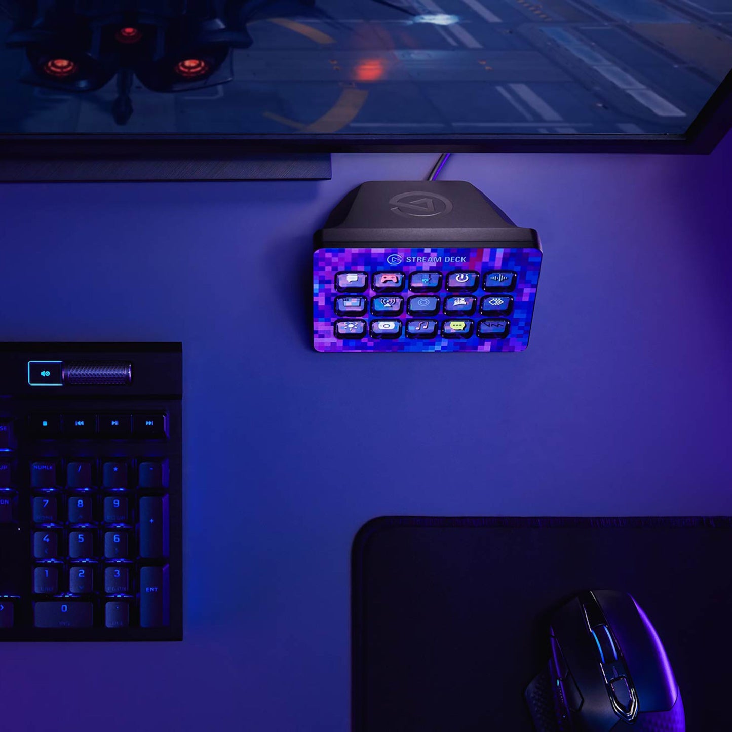 Elgato Stream Deck Mk. 2 med programmerbare knapper, mekanisk tastatur, mus og musemåtte under lilla/blåt lys.