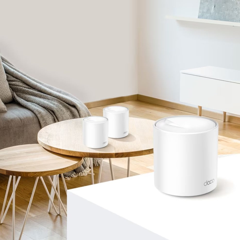 TP-Link Deco X60 V3.20 Mesh System AX5400, 3 hvide cylindrede routere, to på sofabord og én på sidebord.