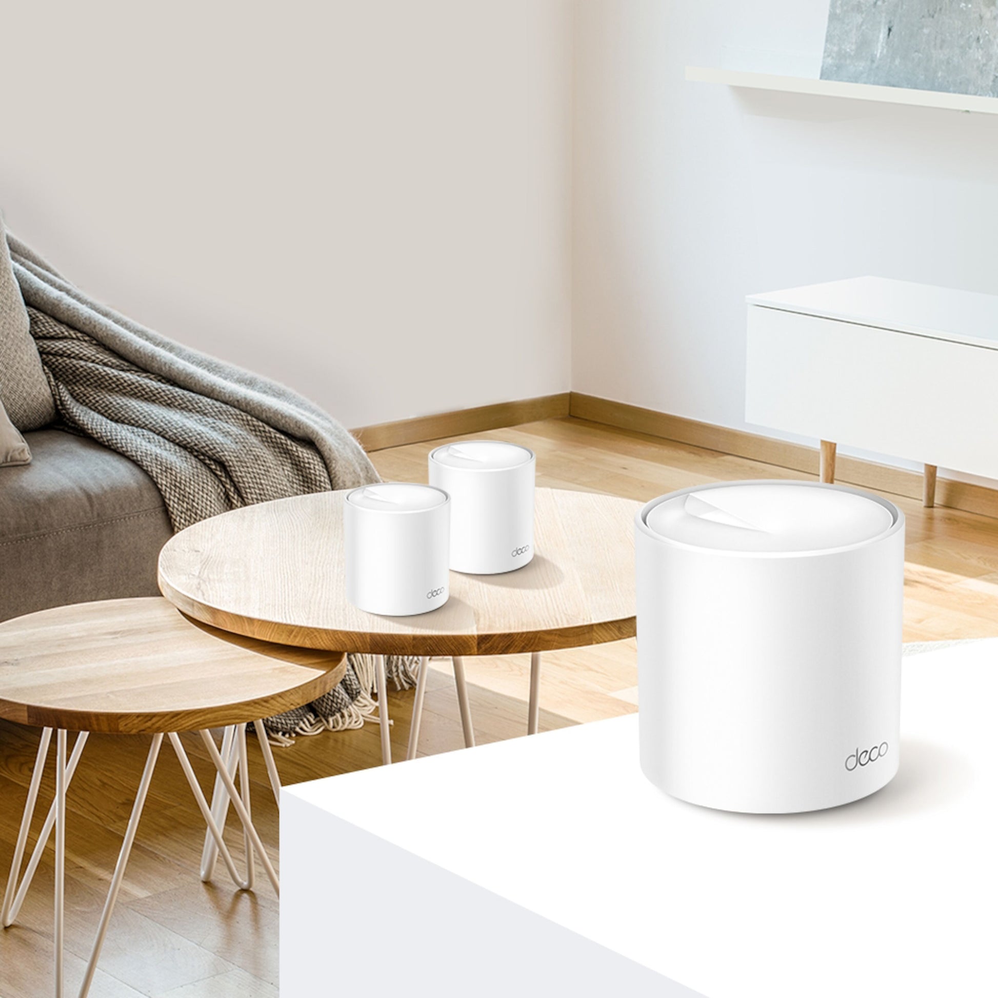 TP-Link Deco X60 V3.20 AX5400 mesh-router hvid, synlig i moderne stue med minimalitisk møbel i baggrunden.