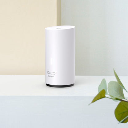 TP-Link Deco X50-Outdoor AX3000 Mesh WiFi 6, hvid, synlig PoE-port, placeret ved grøn plante.