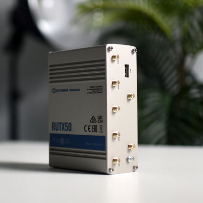 Teltonika RUTX50 5G-router i sølv med modem, stående opret og viser porte, dual SIM til mobilt bredbånd.