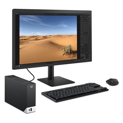 Seagate One Touch Desktop ekstern harddisk 8TB tilsluttet pc med bredskærm, sort tastatur og mus.
