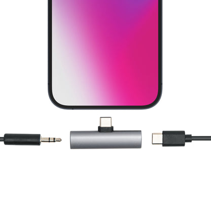 Smartphone med USB-C til USB-C og 3,5 mm lydadapter til opladning og lyd, viser stik klar til tilslutning.