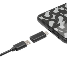 Plexgear USB-C til Micro-USB adapter sølvfarvet ved siden af smartphone med sort-hvidt mønster på skærm.