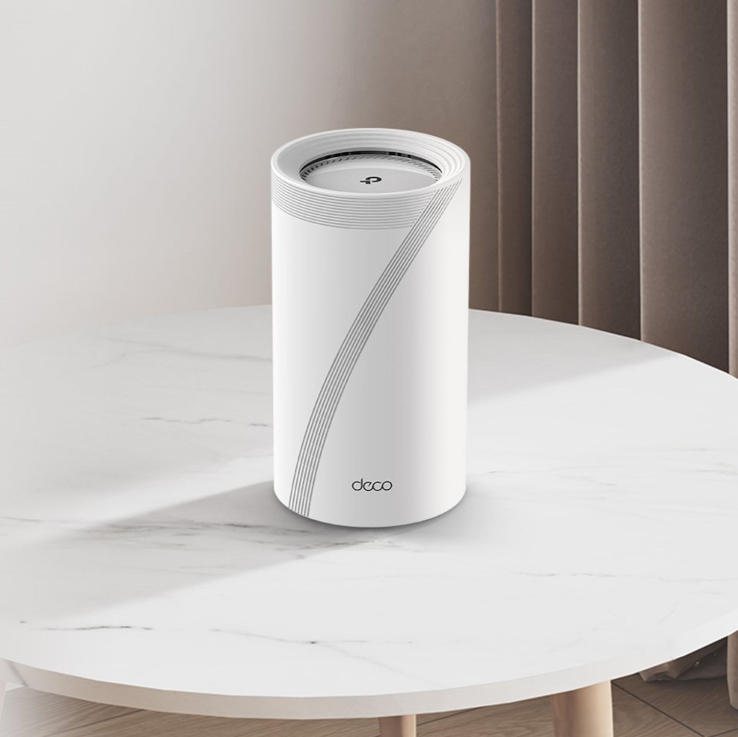 TP-Link Deco BE65 Mesh-router Wifi 7 BE9300 2-pack på bord med marmormønster foran beige lodrette gardiner.