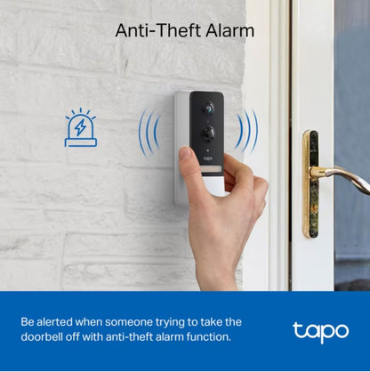 TP-Link Tapo D230S1 smart dørklokke med 2K video på hvid murstensvæg, anti-tyveri alarm ikon synligt.