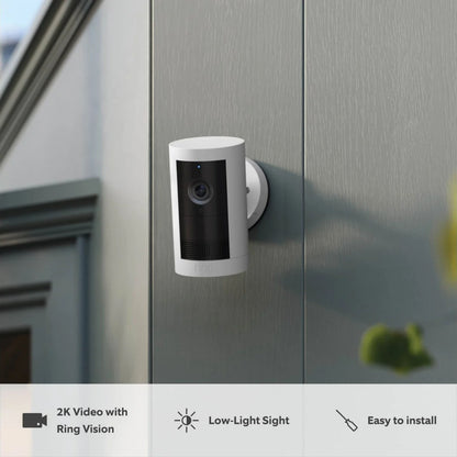 Ring Outdoor Cam Plus Plug-in hvid monteret på ydervæg, viser 2K video, nattenfunktion og nem installation.