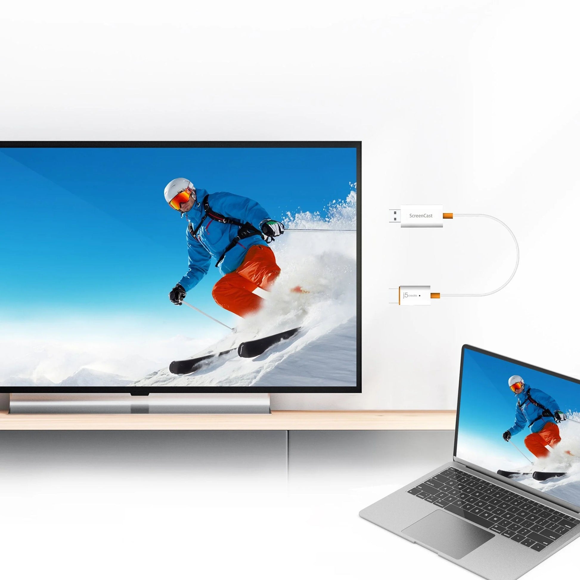 J5create SkærmCast trådløs adapter viser laptop-indhold trådløst på TV, skiløber midt i foråret vises på skærmen.