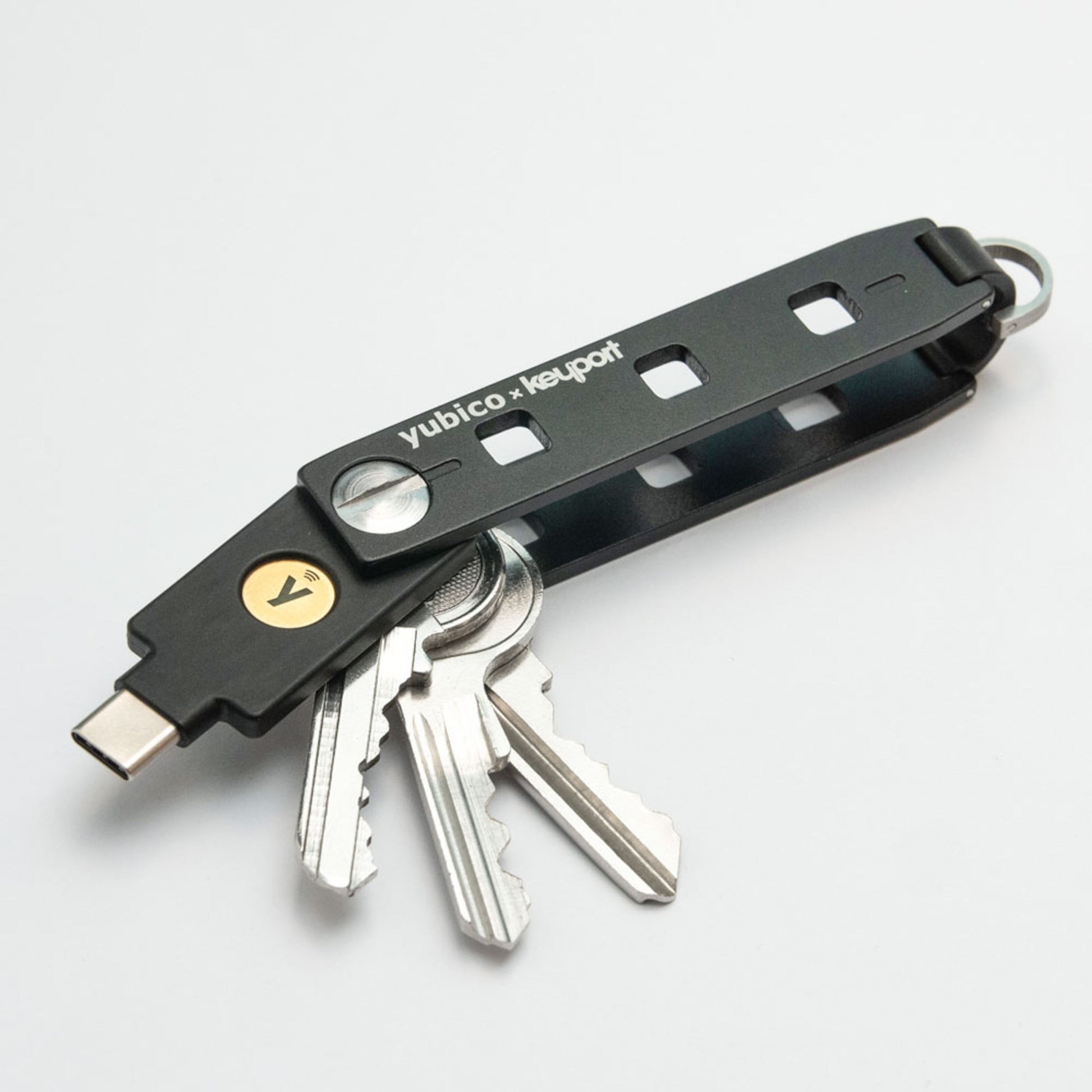 Sort Yubico x Keyport nøgleorganizer med tre metalnøgler og Yubico Sikkerhedsnøgle NFC USB-C, guldfarvet NFC-knap.