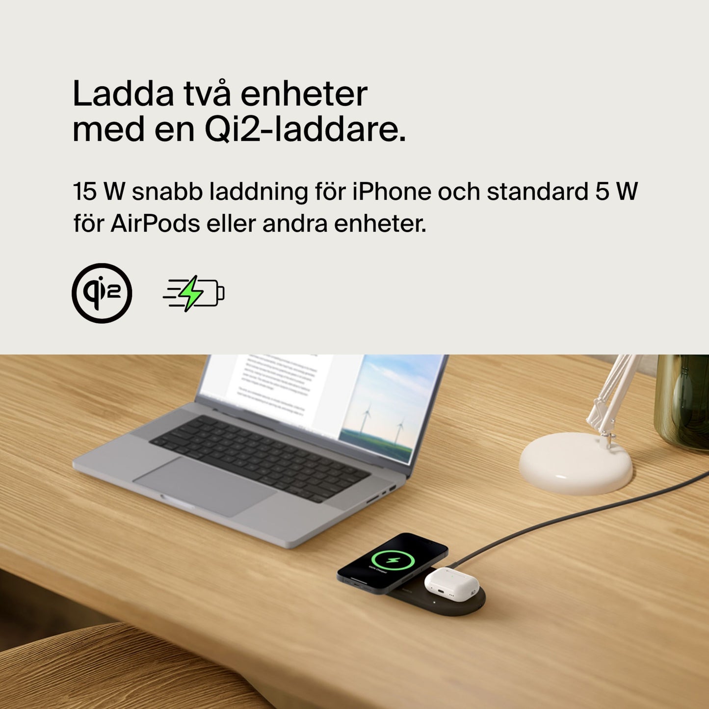Belkin BoostCharge Pro 2-i-1 Qi2 15 W oplader til iPhone og AirPods på skrivebord ved siden af åben bærbar og lampe.