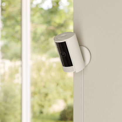 Ring Indoor Cam Gen 2 trådløst overvågningskamera hvid monteret på væg, synlig ledning, optager i 1080p Full HD.