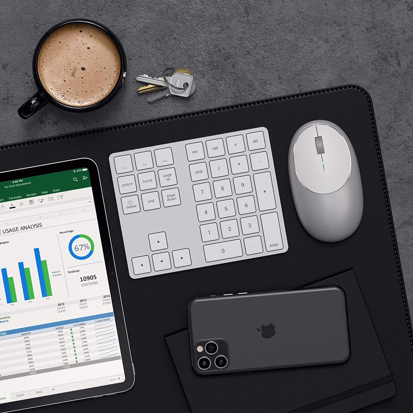 Satechi Trådløs Numpad Sølv på sort skriveunderlag med mus, iPhone, iPad m. Excel-ark, kaffekop og nøgler.