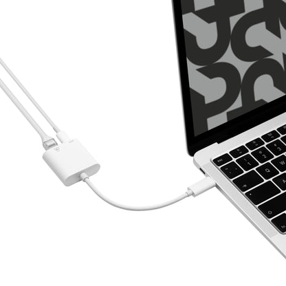 Gigabit-netværkskort med PD-opladning USB-C tilsluttet sølvfarvet laptop, til kabler forbundet, skærm med abstrakt mønster.
