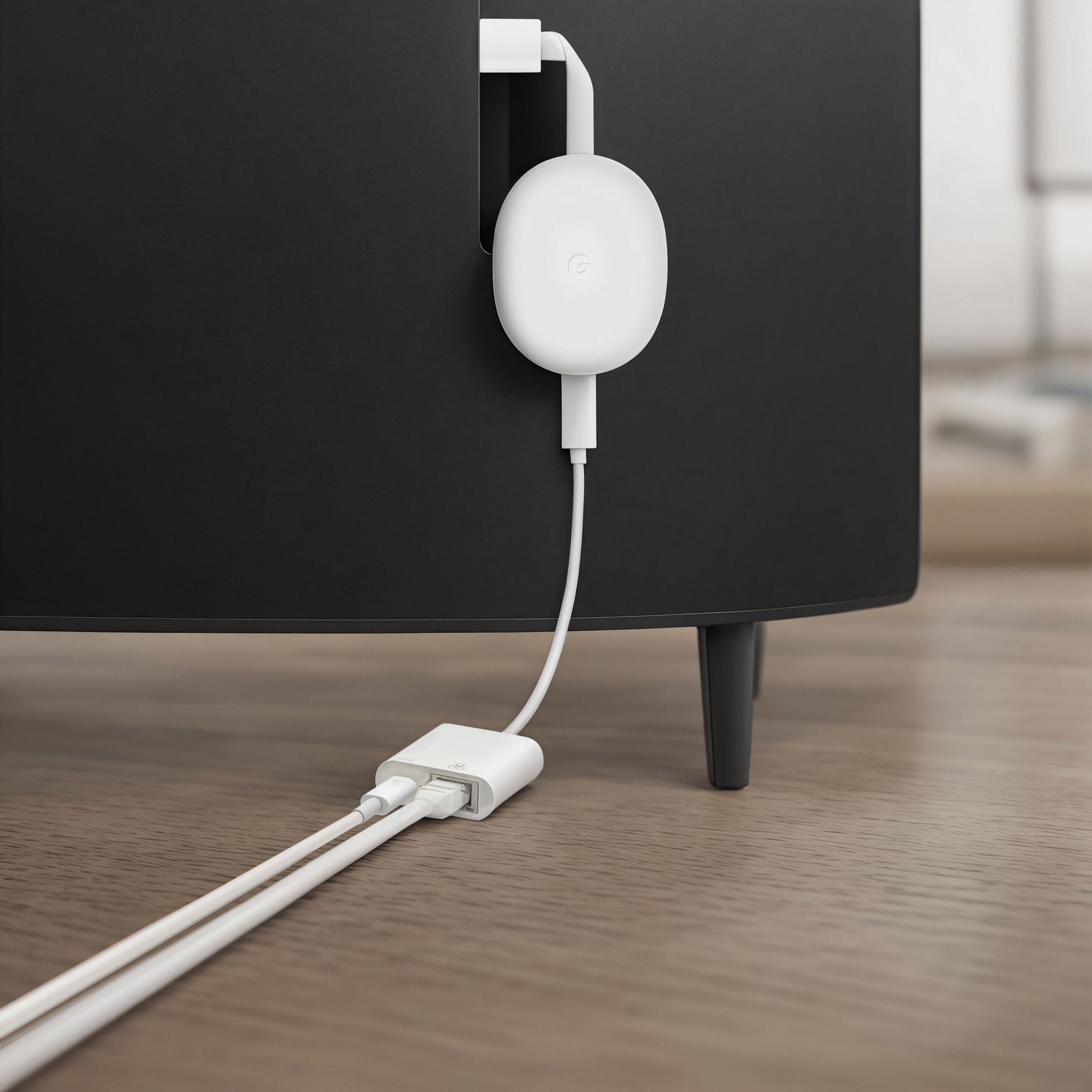 Chromecast med Google TV tilsluttet bag sort TV-møbel, USB-strømkabel til adapter, Gigabit-netværkskort USB-C PD vises.