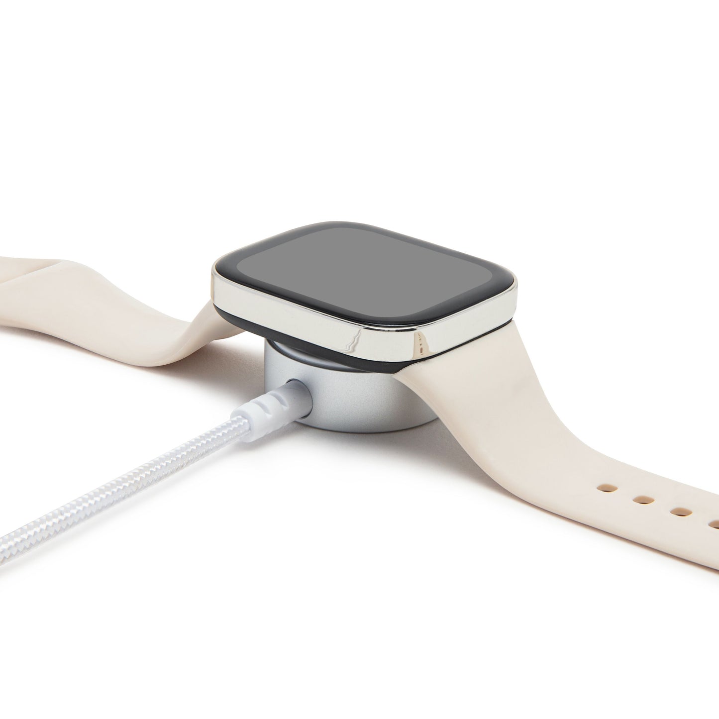Beige smartwatch med silikonerem på rund magnetisk ladeplade forbundet med 1,2 m Apple Watch USB-C opladningskabel.