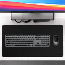 Apple iMac, Satechi X3 trådløst tastatur med numerisk tastatur, mus og sort Satechi skrivebordsmåtte, kabler og telefon.