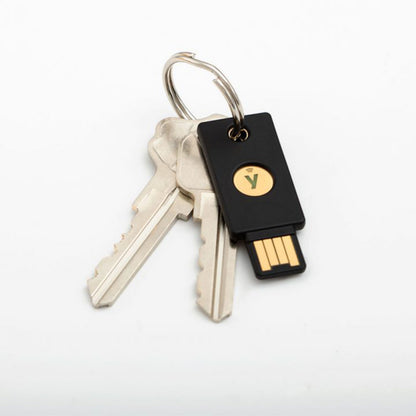 To sølvfarvede husnøgler og sort Yubico YubiKey 5 NFC USB-A sikkerhedsnøgle samlet på en nøglering.