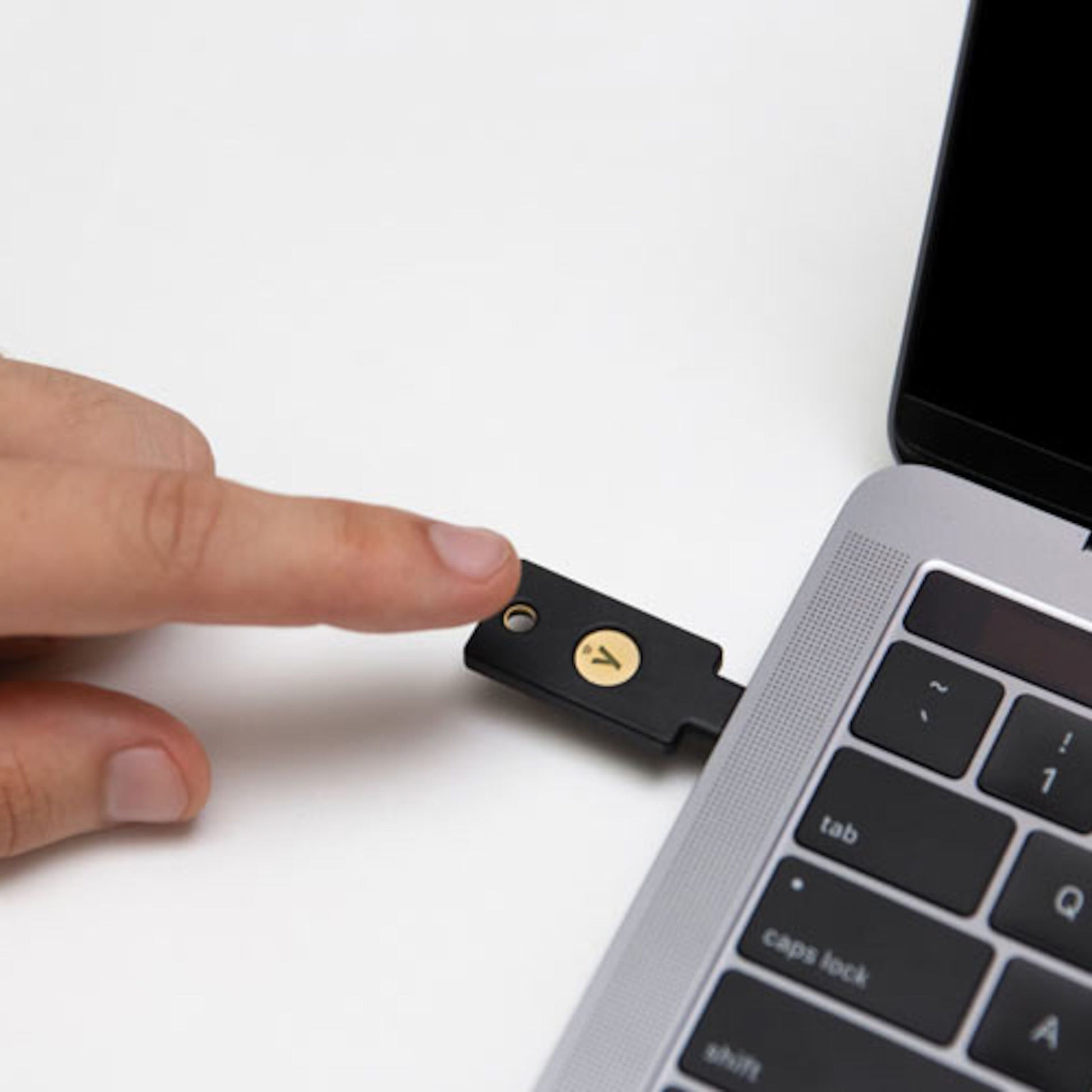 Yubico YubiKey 5C NFC Sikkerhedsnøgle med USB-C i laptop USB-C port, tastatur og trackpad synlig, tofaktorautentisering.