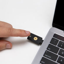 Yubico YubiKey 5C NFC Sikkerhedsnøgle med USB-C i laptop USB-C port, tastatur og trackpad synlig, tofaktorautentisering.