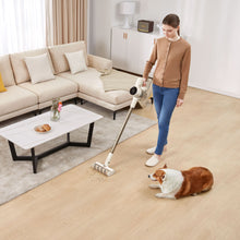 Dreame R10 støvsuger bruges på lyst trægulv med krummer nær corgi, beige sofa og hvidt sofabord synlige.