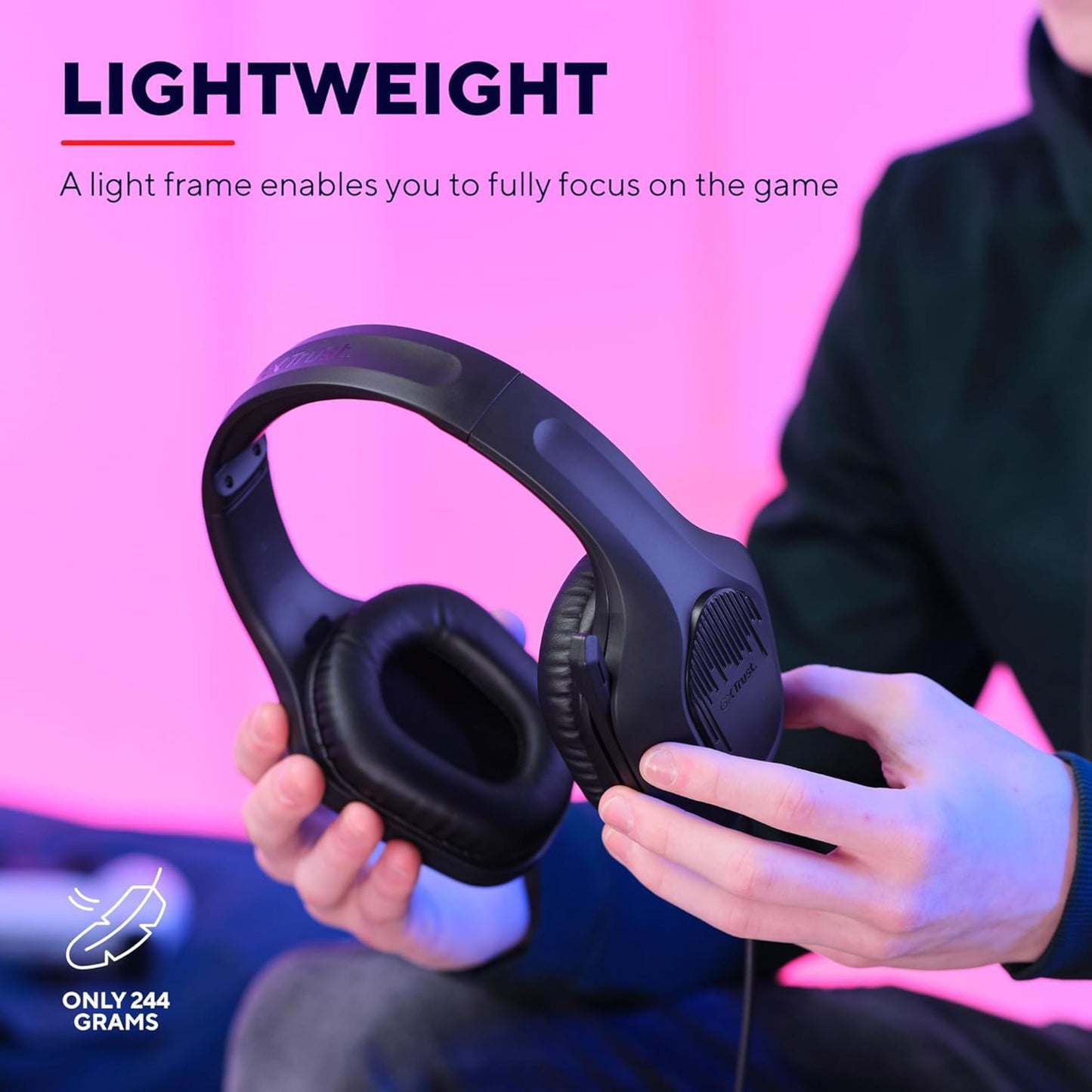 Trust GXT415 Zirox sort over-ear gaming headset, 244g, vises i hånd mod pink baggrund.