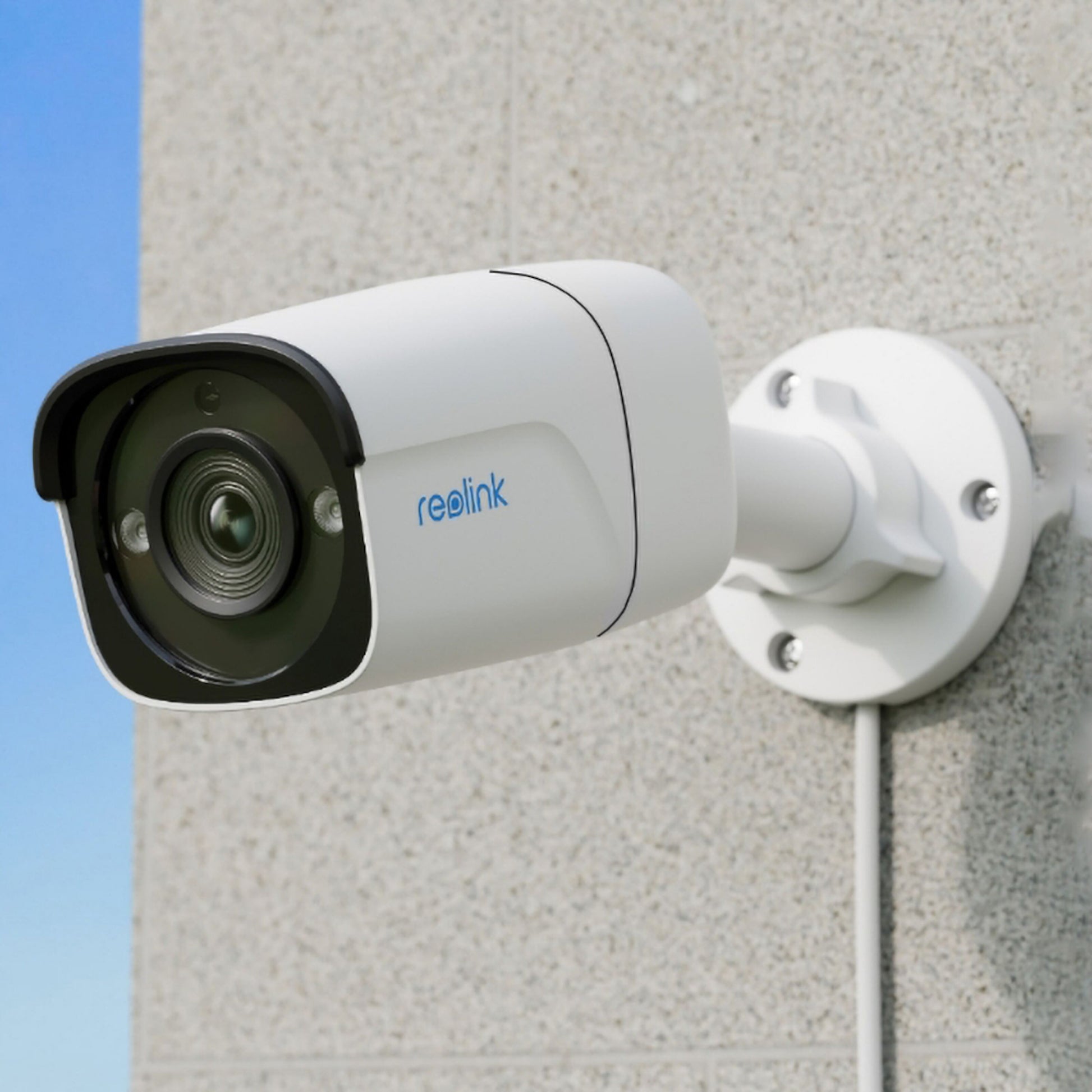 Reolink P320 POE udendørskamera 5 MP hvid, monteret på lys væg, synlig linse og kabel, persondetektering.
