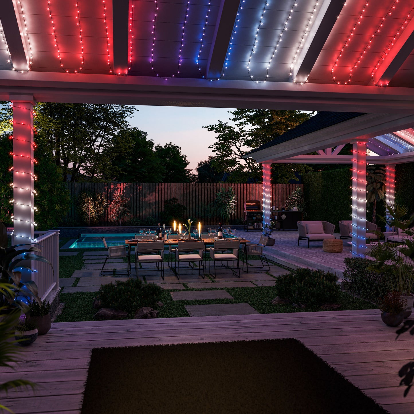 Philips Hue Festlig lyskæde 250 LED på pergola i have med spisebord, stearinlys og pool synligt.