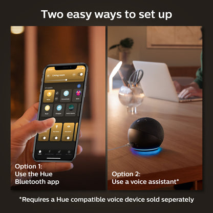 Smartphone med Hue Bluetooth-app samt smarte højttalere ved siden af Philips Hue White Ambience E27 LED-pære 800 lm 2-pak.
