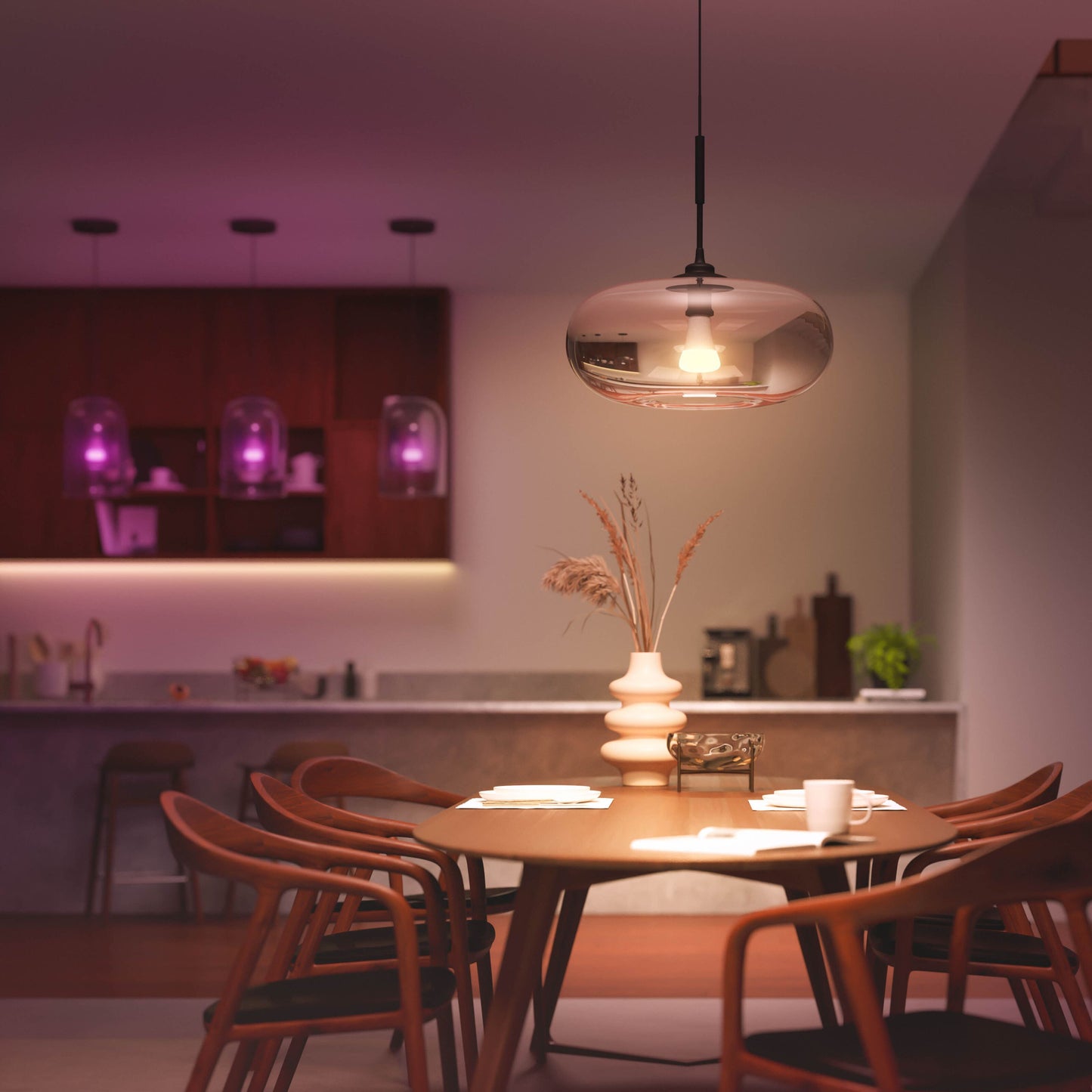 Philips Hue Color Ambiance Smart LED-pære E27 1600 lm pendellampe over rundt træbord, lilla lys i køkken.