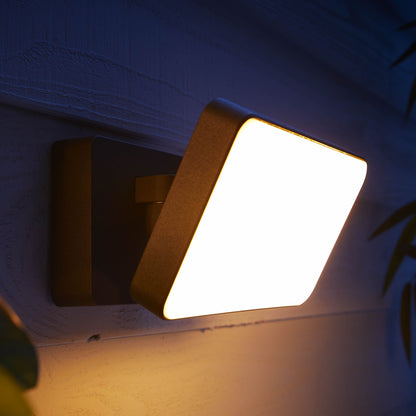 Philips Hue Opdag udendørs projektør 2250 lm monteret på ydervæg, lyser med varm hvidt lys i mørke.