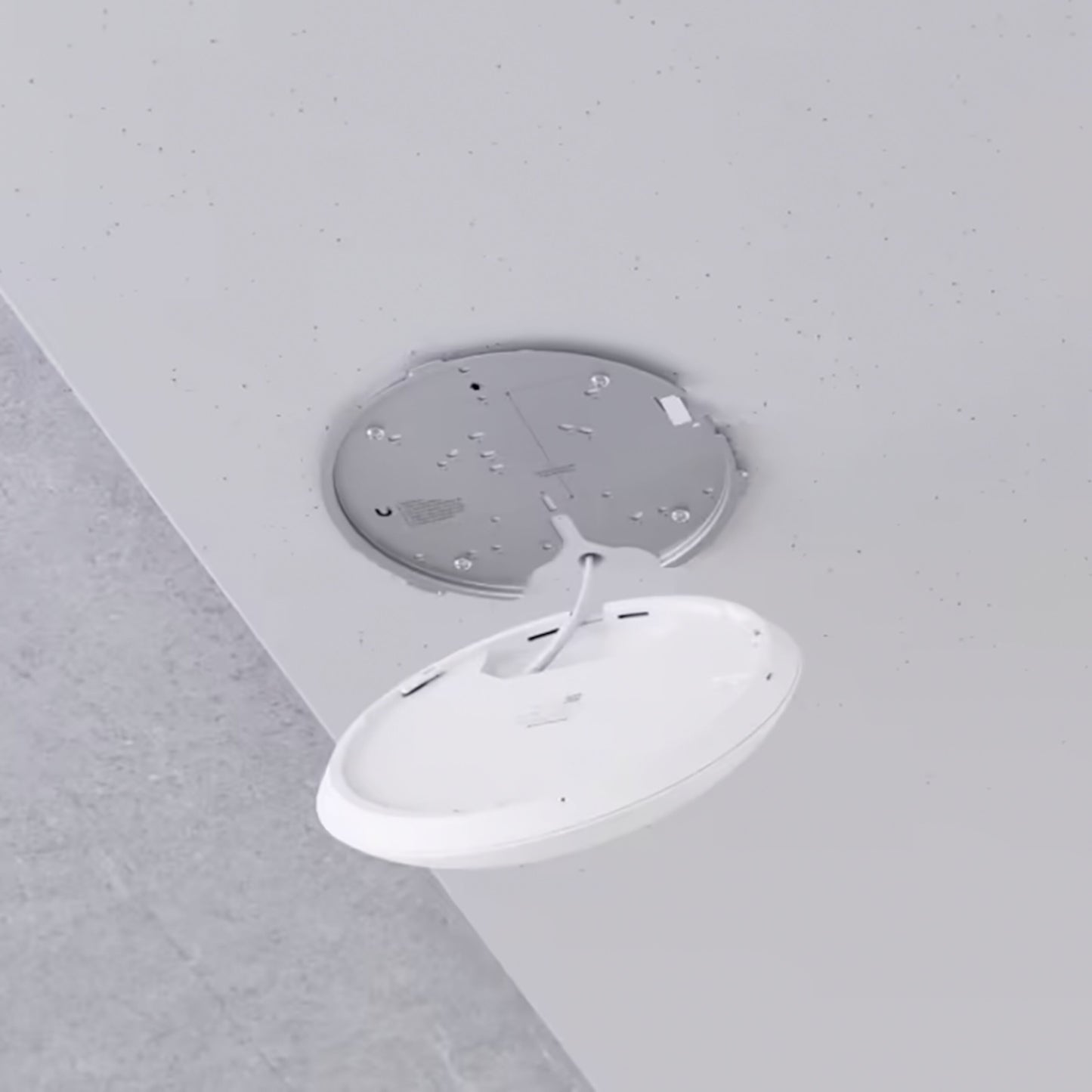 Ubiquiti Unifi U7 Pro access point hvid rund, Wifi 7, loftmontering, åben med synlige ledninger og metal monteringsplade.