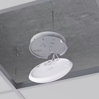 Ubiquiti Unifi U7 Pro adgangspunkt Wifi 7, rund hvid enhed uden cover, synlige ledninger, grå betonloft.