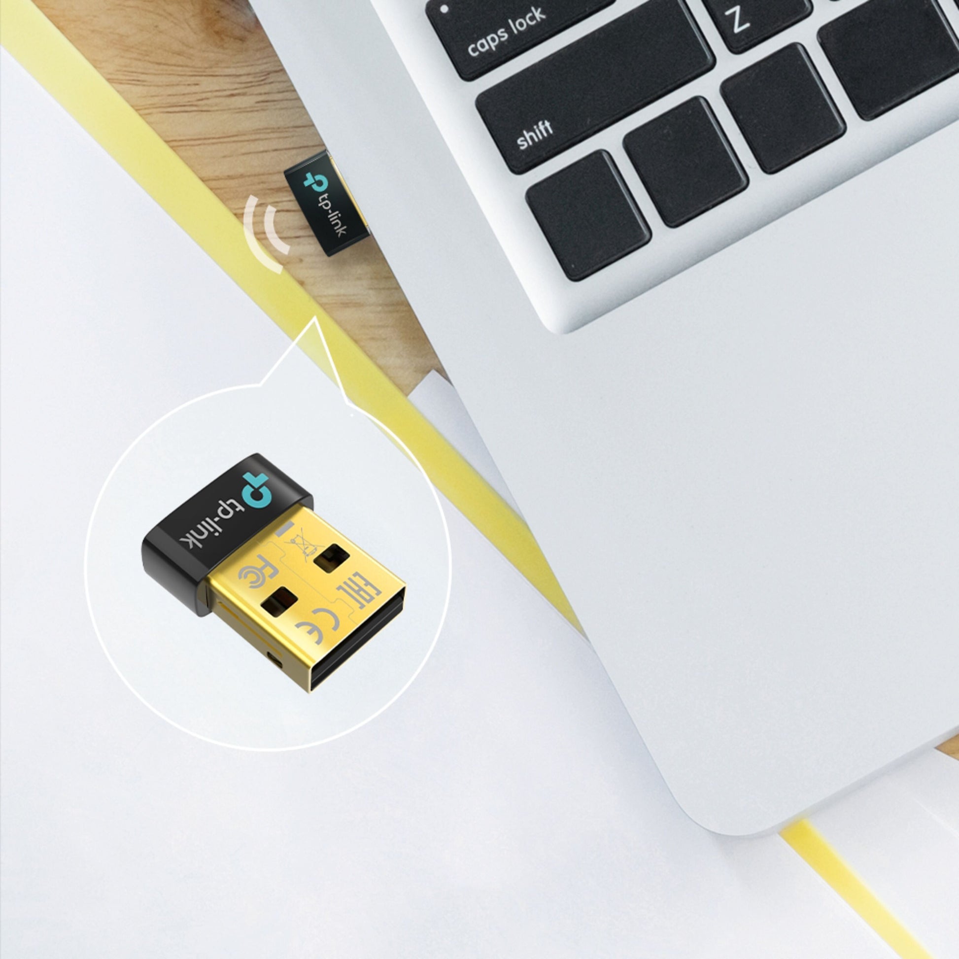 TP-Link Bluetooth 5.3-modtager delvist tilsluttet sølvfarvet laptop, nærbillede viser USB-stik og logo.