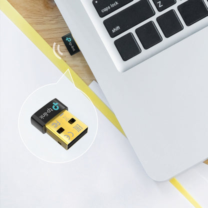 TP-Link Bluetooth 5.3-modtager delvist tilsluttet sølvfarvet laptop, nærbillede viser USB-stik og logo.