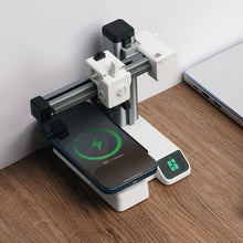 Bambu Lab 3D-sæt til trådløs oplader ved laptop, smartphone med grøn opladeikon, CNC-maskine i baggrunden.