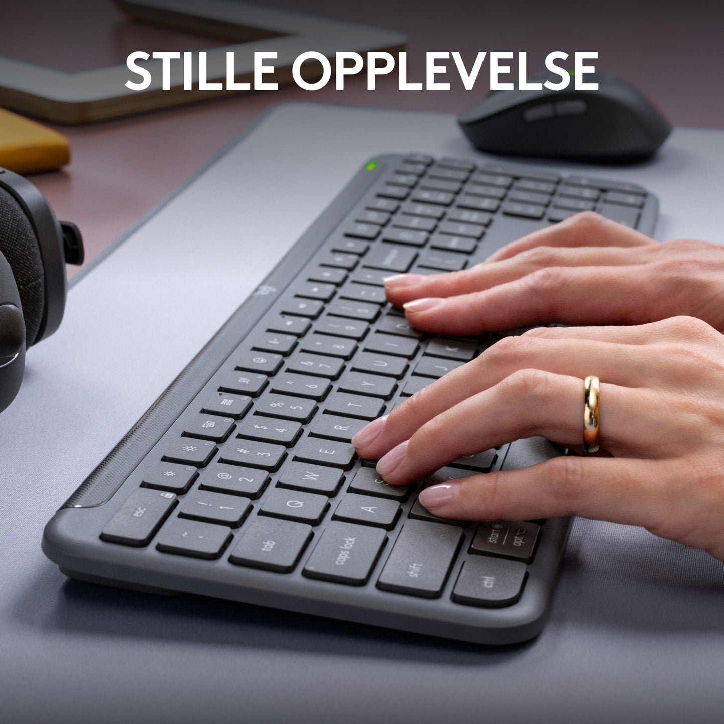 Logitech MK950 Signature Slim trådløst tastatur og mus, tæt på hænder, norsk tekst "STILLE OPPLEVELSE" synlig.