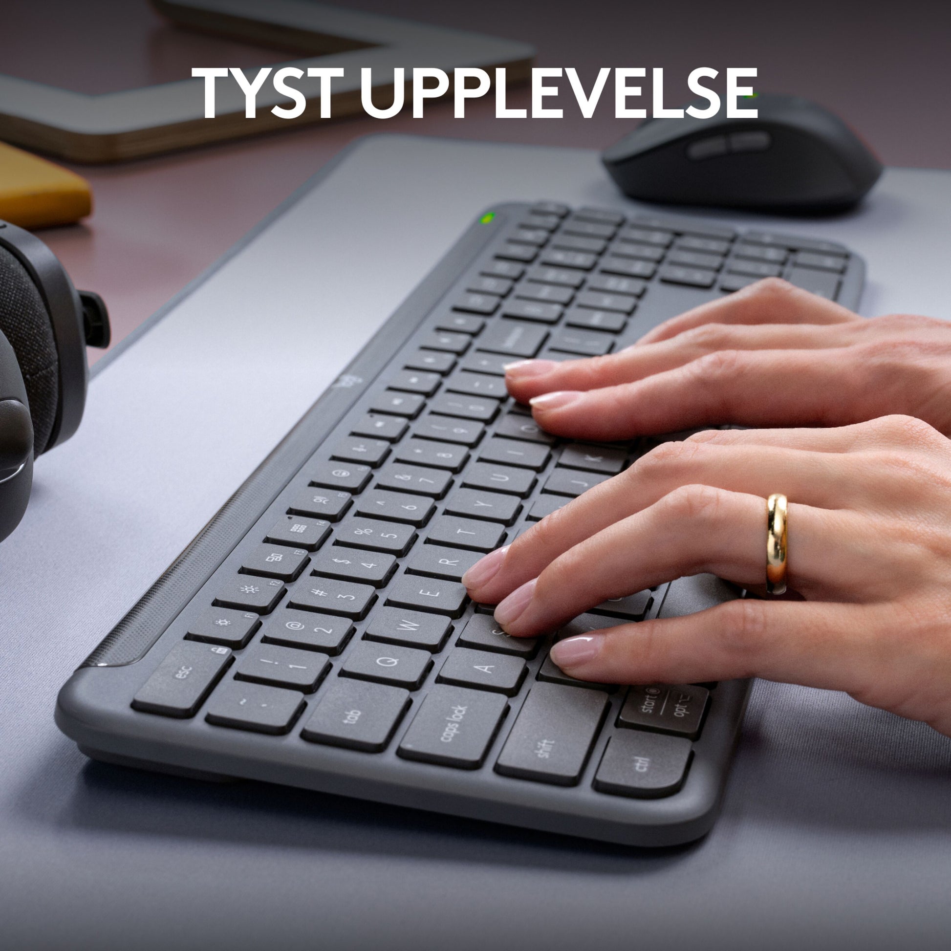 Logitech MK950 Signature Slim trådløst tastatur og mus, grå, hænder taster, tekst "TYST UPPLEVELSE" synlig.