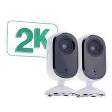 Arlo Essential 2K indendørskameraer side om side på stativer med grøn 2K videoopløsning og bevægelsesregistrering grafik.