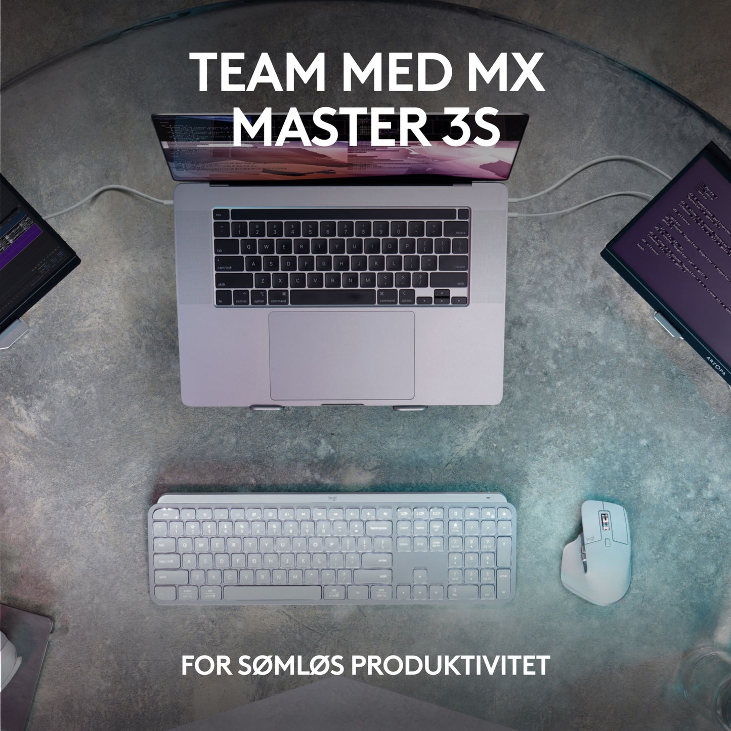 Logitech MX Keys S trådløst tastatur grafit, mus og laptop på skrivebord oppefra, delvist til monitorskærme, tekst på skærm.