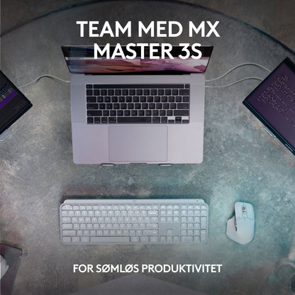 Logitech MX Keys S trådløst tastatur grafit, mus og laptop på skrivebord oppefra, delvist til monitorskærme, tekst på skærm.