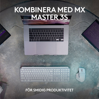 Logitech MX Keys S trådløst tastatur grafit, MX Master 3S mus, bærbar og to skærme set ovenfra.