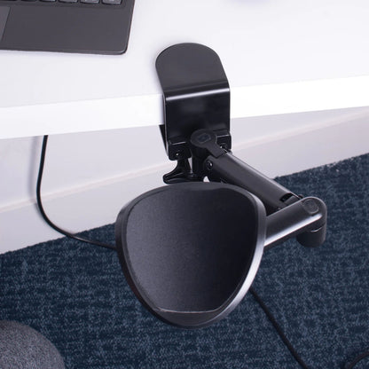 Desire2 MouseMate musestøtte monteret på skrivebordskant ved laptop, placeret på blåt tekstureret tæppe.