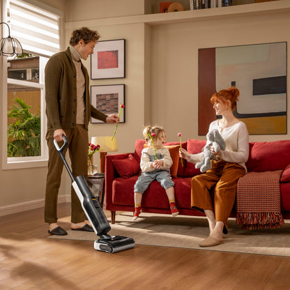 Roborock F25 Støvsuger Sort i stue med mand, pige på rød sofa og kvinde med bamse, moderne hjem.