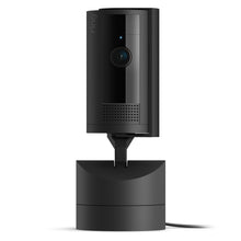 Ring Pan-Tilt indendørs kamera sort, rund linse, 360° panorering, LED-indikator, højttalergitter, synlig ledning fra base.
