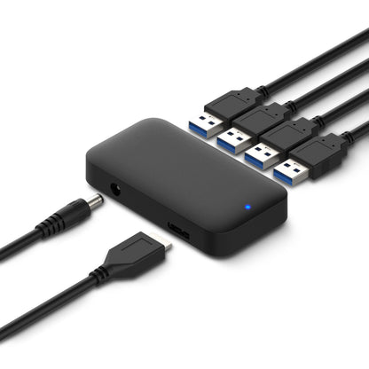 Sort USB 3.0 hub 4-vejs med fire tilsluttede USB-kabler, strømforsyningskabel, datakabel og lille blå indikatorlysdiode.