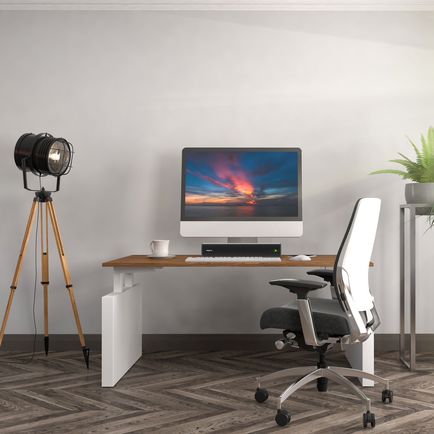 Creative Scene Air V2 Bluetooth soundbar på træbord med computer, hvid stol og plante, lysgrå væg, sildebensgulv.